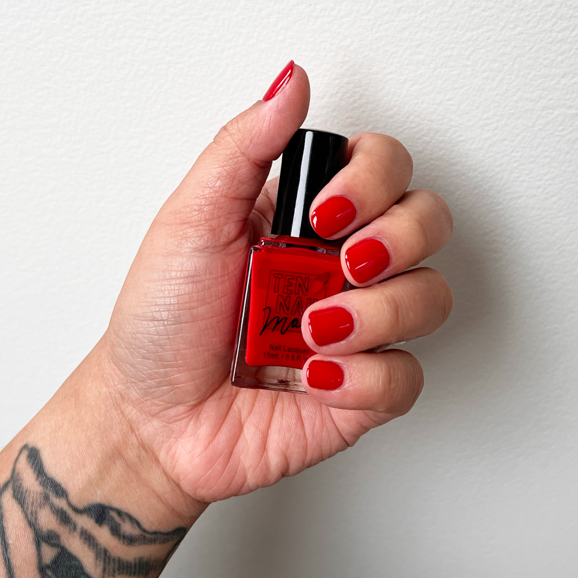 Castor Bean painted on fingernails with tattooed arm