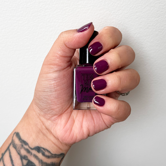 Deadly Nightshade painted on fingernails with tattooed arm